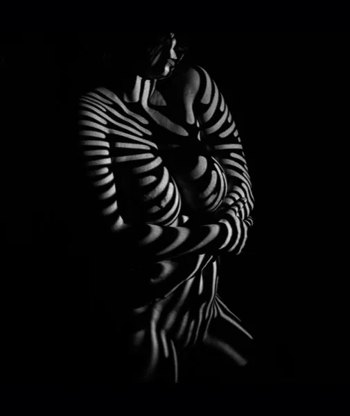 Zebra-striped shadows across a body — light revealing what was hidden