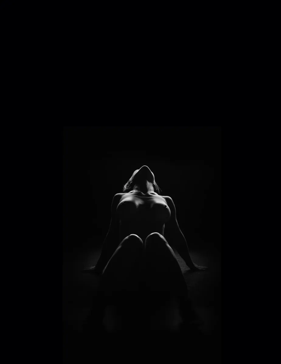 Seated figure from behind — fine art nude with dramatic rim lighting